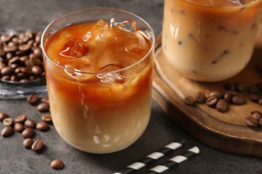 Gri masada lezzetli buzlu kahve ve fasulye, yakın plan.