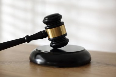 Hakimin tokmağı ahşap masada, arka planda ışığa karşı, yakın plan.