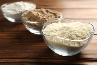 Tahta masadaki kaselerdeki farklı un türleri, yakın plan.