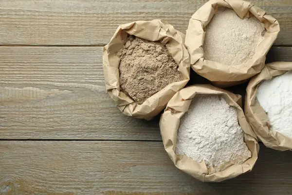 Tahta masadaki kağıt torbalarda farklı türde un var. Metin için boşluk