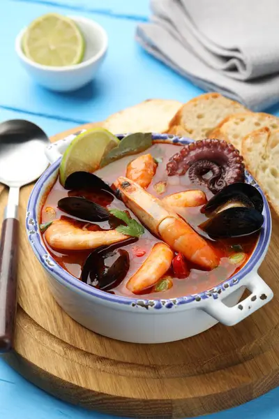 Lezzetli deniz ürünleri çorbası mavi masada, yakın plan.