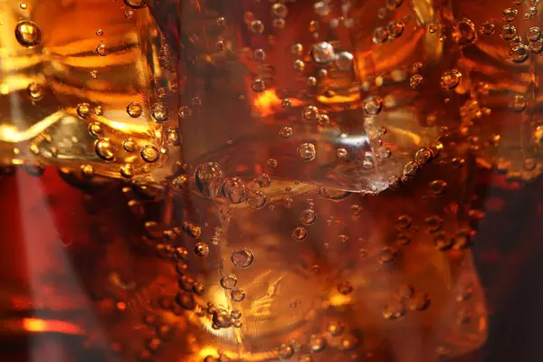Arkaplan olarak buz küpleriyle kola tazeleniyor, makro görünüm