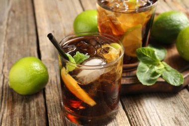 Küba libre kokteylini ahşap masada nane şekeri ile tazeliyorum.