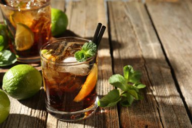 Küba libre kokteylini ahşap masada nane şekeriyle tazeliyorum. Metin için boşluk