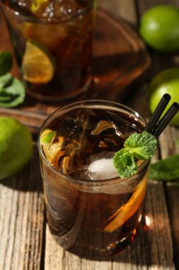 Küba libre kokteylini ahşap masada nane şekeriyle tazeliyorum.