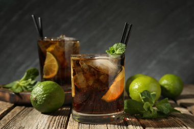 Küba libre kokteylini ahşap masada nane şekeriyle tazeliyorum.