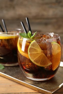 Küba libre kokteylini ahşap masada nane şekeri ile tazeliyorum.