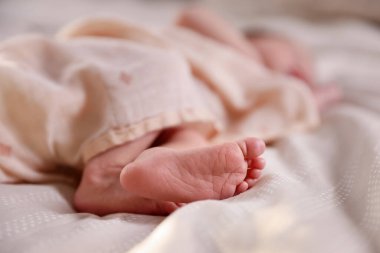 Küçük bebek yatakta uzanıyor, yakın plan.