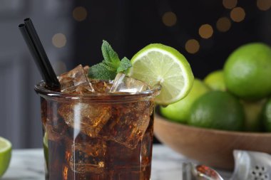 Lezzetli Küba Libre kokteyli, cam, limon ve maşa, yakın plan. Bokeh etkisi