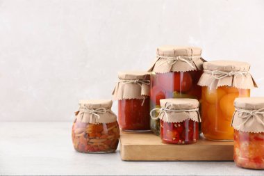 Işık masasında farklı turşu ürünleri olan bir sürü kavanoz. Metin için boşluk