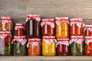 Ahşap masada farklı turşu ürünleri olan bir sürü kavanoz.