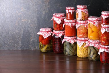 Ahşap masada farklı turşu ürünleri olan bir sürü kavanoz, metin için yer.