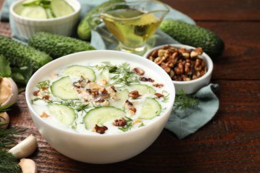 Ahşap masada dereotlu ve fındıklı leziz salatalık çorbası.