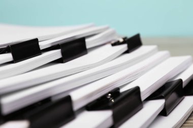 Masanın üzerinde kağıt kağıtları olan ataçlar, yakın plan