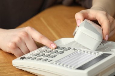 Ahşap masada telefonla arayan kadın, yakın plan.