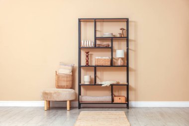 Dekor, sepet ve yastıklı raf ünitesi bej duvarın yanında.