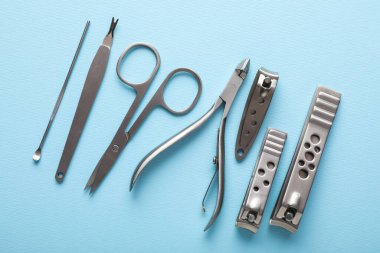 Açık mavi zemin üzerinde farklı manikür araçları kümesi, düz yatıyordu