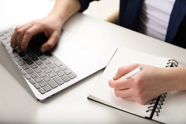 İçerideki masada ders sırasında not alan bir adam, yakın plan. Kendi kendine çalışma.