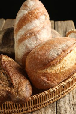 Tahta masadaki sepetin içinde farklı somunlar, yakın çekim.