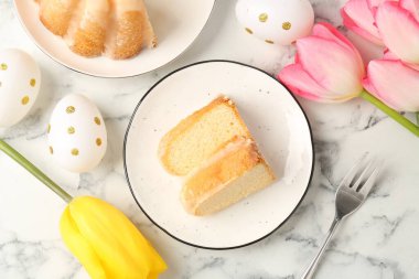 Lezzetli kek parçaları, Paskalya yumurtaları ve laleler açık mermer masa üzerinde, düz yatıyordu.