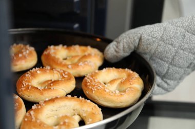 Fırından taze krakerlerle fırın yapan kadın, yakın plan.