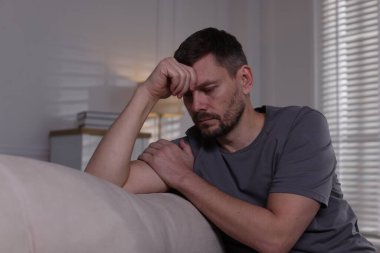 Evdeki kanepede depresif bir adam. Zihinsel sağlık sorunu