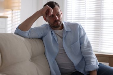 Evdeki kanepede depresif bir adam. Zihinsel sağlık sorunu