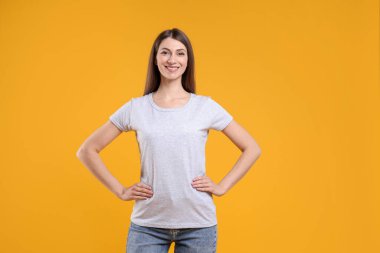 Turuncu arka planda beyaz tişört giyen bir kadın. Tasarım için model