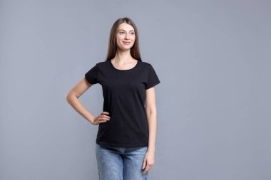 Açık gri arka planda siyah tişört giyen bir kadın. Tasarım için model