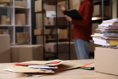 Masada bir sürü farklı zarf ve postanede çalışan kadın, seçici bir odak