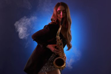 Profesyonel müzisyen dumanla arka planda saksafon çalıyor