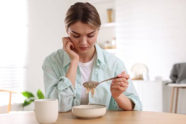 İç mekanlarda iştah kaybı yaşayan depresif bir kadın.