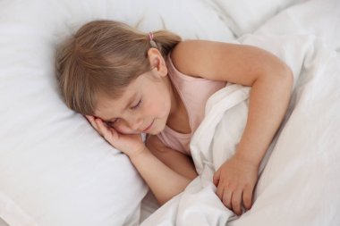 Yatma vakti. Yatakta uyuyan tatlı küçük kız.