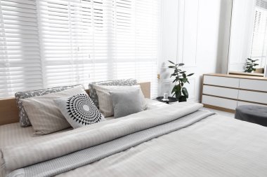 Şık bir odada yumuşak çarşafları olan rahat bir yatak, yakın çekim. İç tasarım