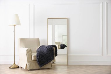 Odadaki koltukta örülmüş merino yün ekose.