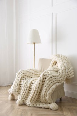Odadaki koltukta örülmüş merino yün ekose.
