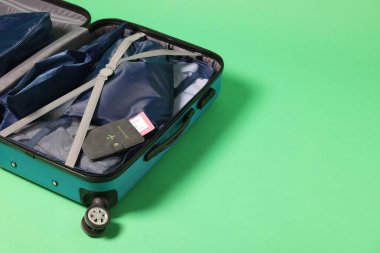 Açık yeşil arkaplan üzerinde giysi, pasaport ve bilet paketleme küpleri, metin için boşluk