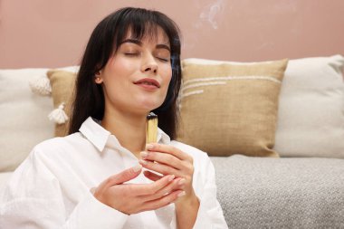 Yanan Palo Santo 'su olan kadın evde takılıyor.