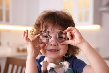 Yemek tarifi. Mutfakta kurabiye keskisi olan sevimli bir çocuk.