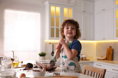 Yemek tarifi. Küçük çocuk mutfaktaki masada kurabiye için para kazanıyor. Metin için boşluk