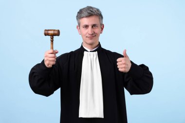 Açık mavi arkaplanda parmak gösteren çekiçli bir yargıç