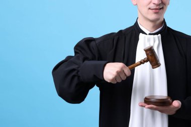 Açık mavi arka planda çekiç ve ses engelli gülümseyen yargıç, yakın plan. Metin için boşluk