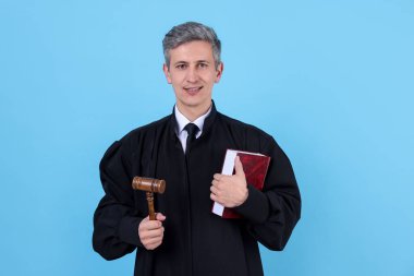 Gülen yargıç elinde tokmak ve açık mavi arkaplan kitabı ile