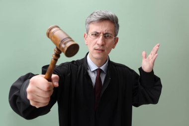 Yeşil arka planda tokmağı olan duygusal yargıç.