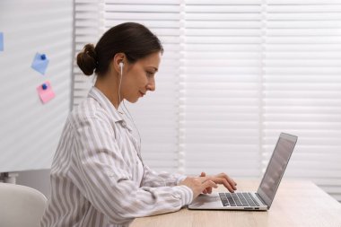 İçerideki masada dizüstü bilgisayarı olan internet hoparlörü.