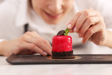 Şekerci, nefis bir tatlıyı nane şekeriyle süslüyor, yakın plan.