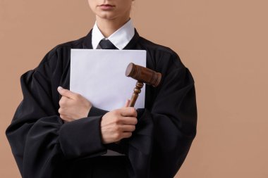 Açık kahverengi arkaplanlı çekiç ve belgeler ile hakim, yakın plan