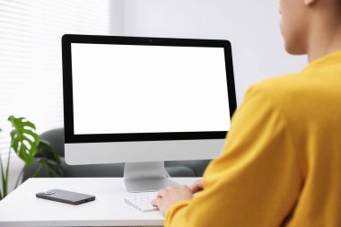 Ofisteki beyaz masada bilgisayarda çalışan bir adam, yakın plan. Tasarım için model