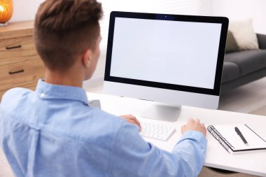 Ofisteki beyaz masada bilgisayarda çalışan bir adam. Tasarım için model