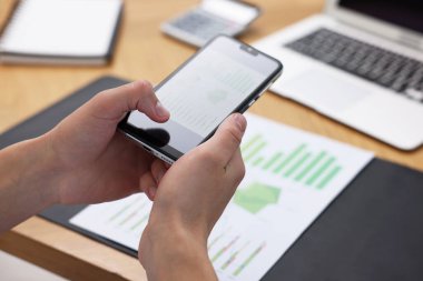 Ofisteki masada akıllı telefondan tarama uygulaması kullanarak belgenin fotoğrafını çeken adam, yakın plan.